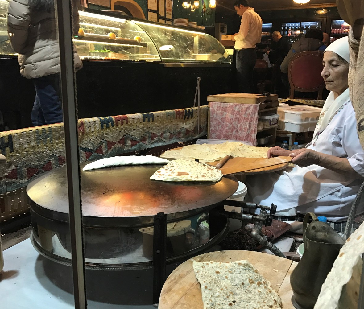 woman-making-fresh-flatbread-by-the-restaurant-window-istanbul-turkey
